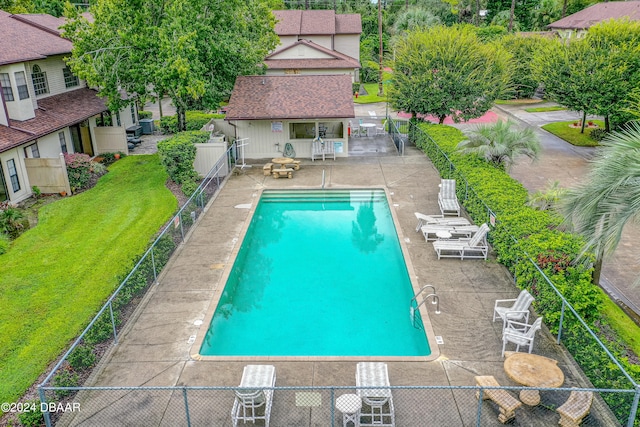 view of swimming pool with a patio area and a yard