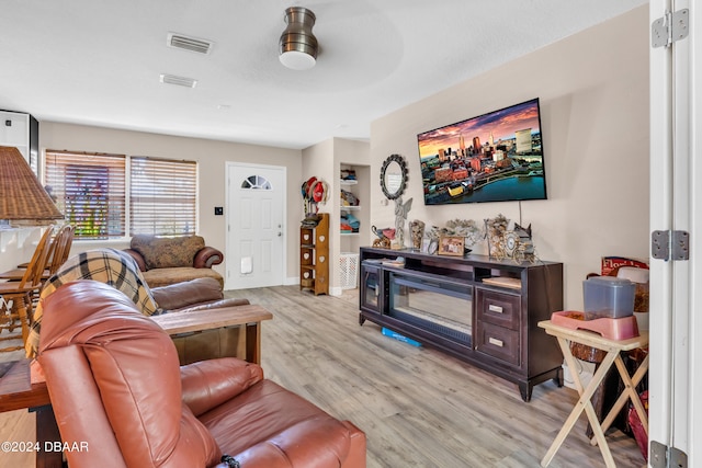 living room with light wood-type flooring and ceiling fan