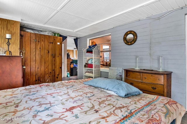 bedroom featuring wooden walls