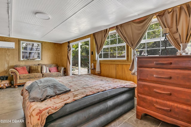 bedroom featuring access to exterior, multiple windows, wooden walls, and a wall mounted AC