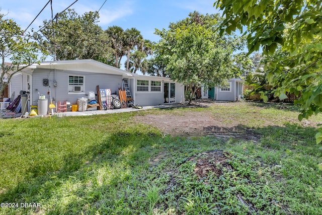 rear view of property with a patio and a lawn