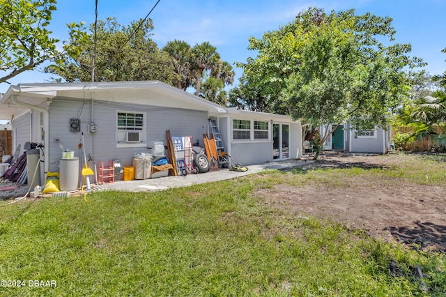 rear view of property with a patio and a yard