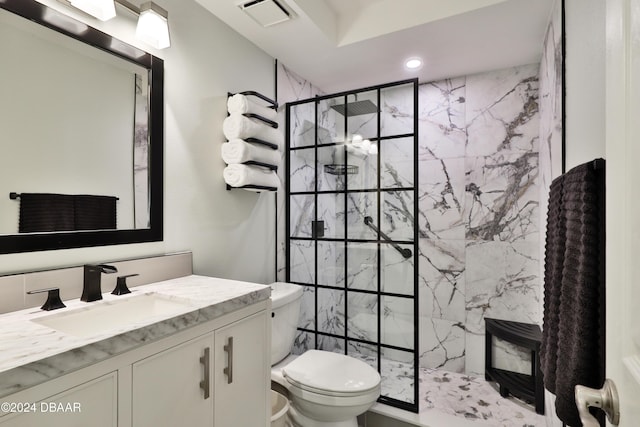 bathroom featuring vanity, toilet, and a tile shower