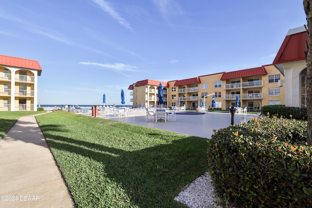 view of home's community with a lawn and a water view