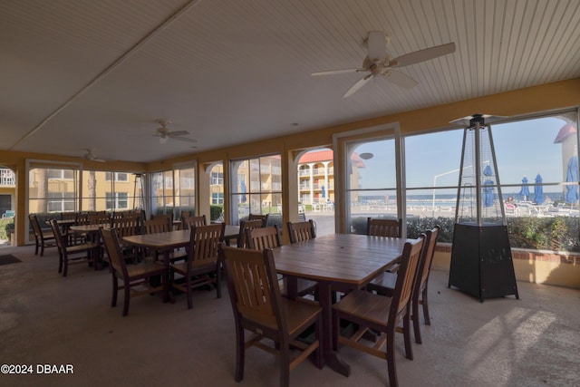 carpeted dining area with plenty of natural light and ceiling fan