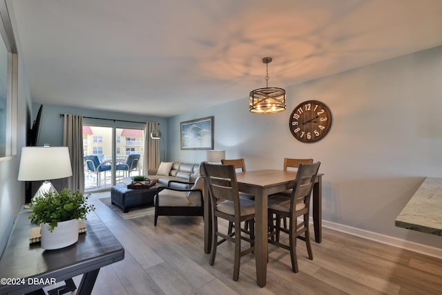 dining space featuring light hardwood / wood-style flooring and a notable chandelier