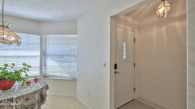 entrance foyer featuring carpet floors, baseboards, and a healthy amount of sunlight