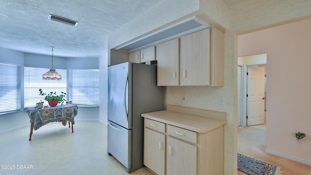 kitchen with visible vents, freestanding refrigerator, baseboards, light countertops, and a textured ceiling