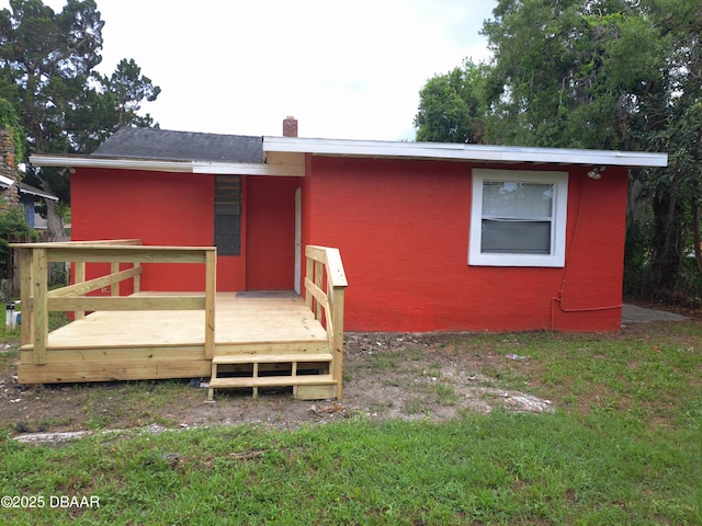 229 S Adams St, Daytona Beach, FL 32117 - rear view of property with a deck, a chimney, and stucco siding