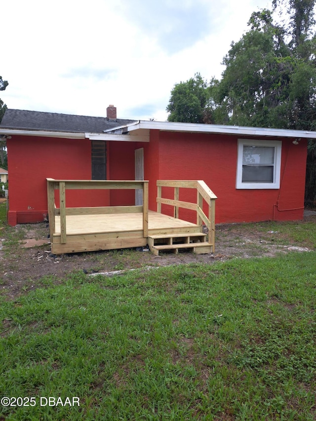 229 S Adams St, Daytona Beach, FL 32117 - rear view of house featuring a wooden deck, a yard, and a chimney