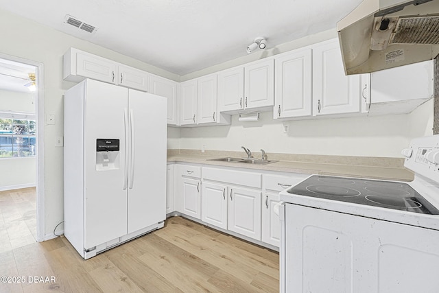 229 S Adams St, Daytona Beach, FL 32117 - kitchen with white appliances, under cabinet range hood, a sink, white cabinets, and light countertops