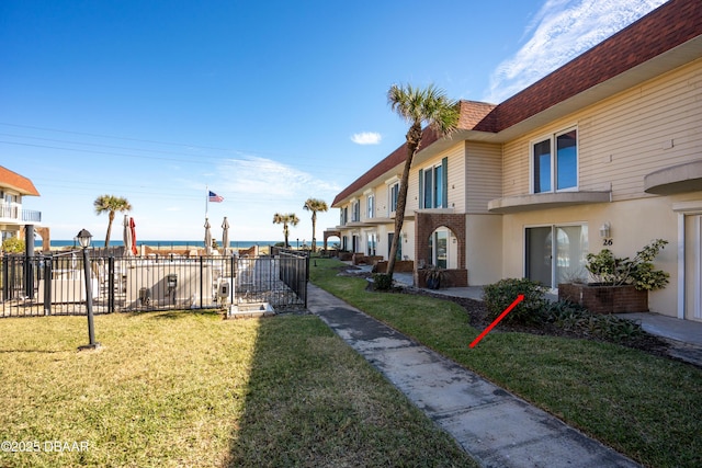 view of property's community featuring a lawn and a water view