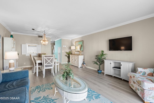 living room with ornamental molding, light hardwood / wood-style flooring, and a notable chandelier