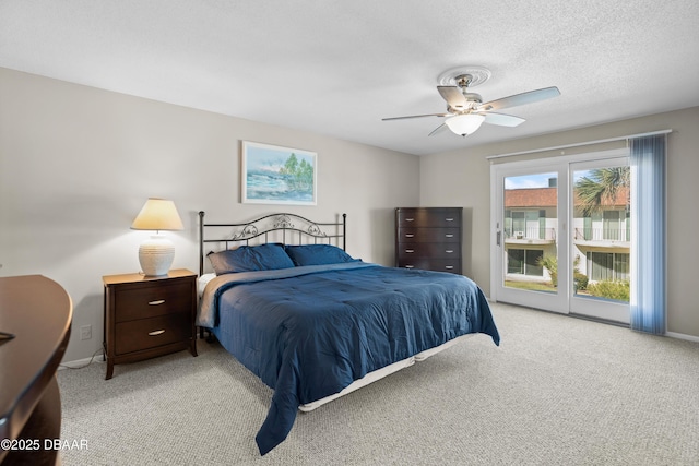 bedroom with ceiling fan, access to exterior, light carpet, and a textured ceiling