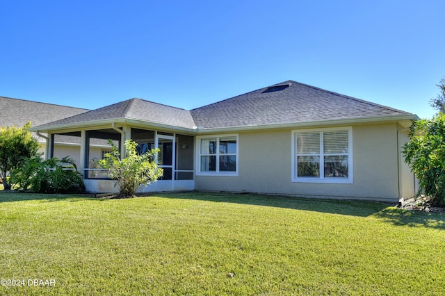 rear view of house with a sunroom and a yard