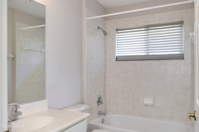 full bathroom with toilet, vanity, and tiled shower / bath