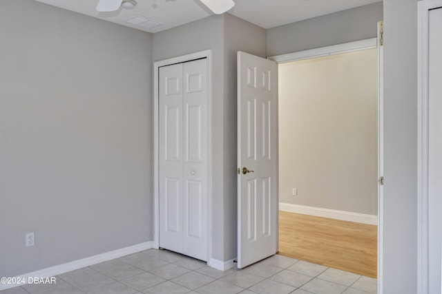 unfurnished bedroom featuring a closet, light hardwood / wood-style floors, and ceiling fan