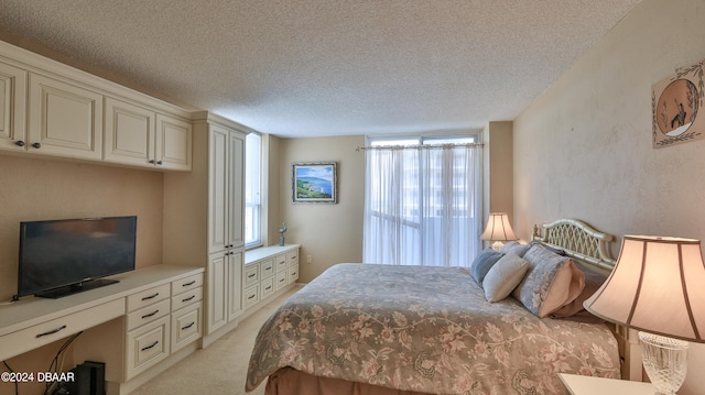 bedroom with a textured ceiling and light carpet