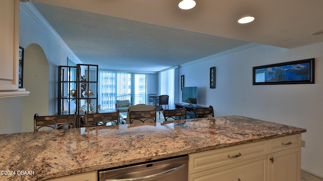 kitchen with white cabinetry, light stone counters, stainless steel dishwasher, and crown molding