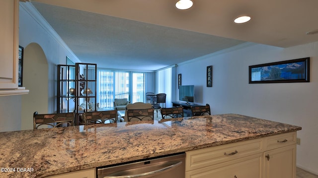2987 S Atlantic Ave Unit 506, Daytona Beach, FL 32118 - kitchen featuring ornamental molding, dishwasher, dark stone countertops, white cabinetry, and open floor plan