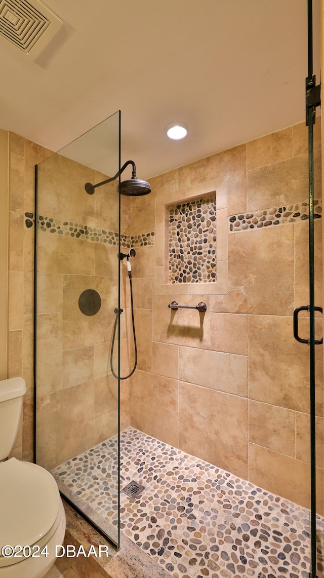 bathroom featuring toilet and an enclosed shower