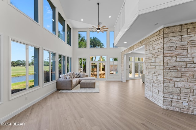 unfurnished living room featuring light wood-type flooring, a healthy amount of sunlight, and ceiling fan