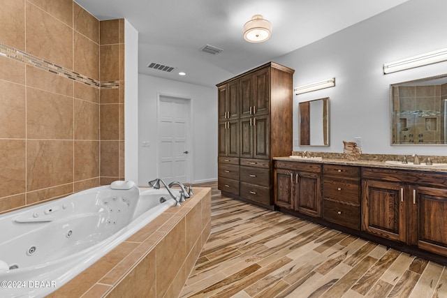 bathroom featuring shower with separate bathtub, wood-type flooring, and vanity