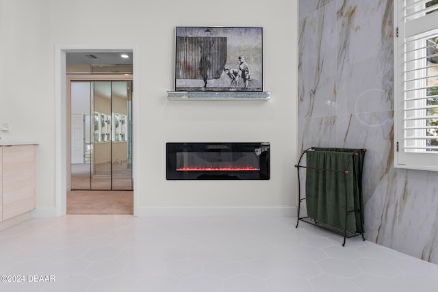 living room featuring a healthy amount of sunlight, tile patterned floors, and tile walls