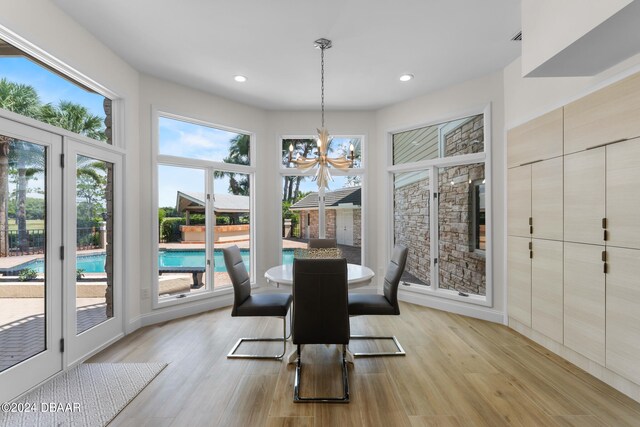 dining room with light hardwood / wood-style floors and an inviting chandelier