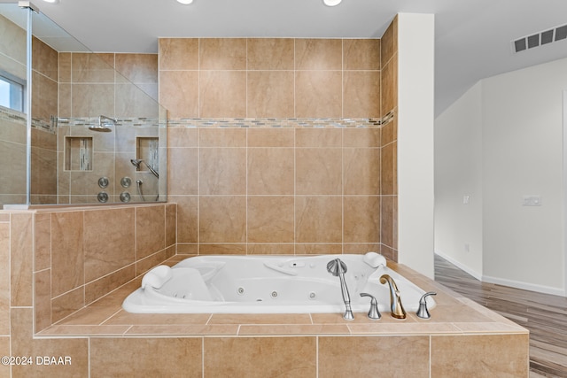 bathroom featuring independent shower and bath and hardwood / wood-style flooring