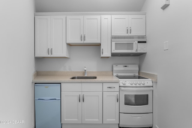 kitchen with white cabinets, sink, and white appliances