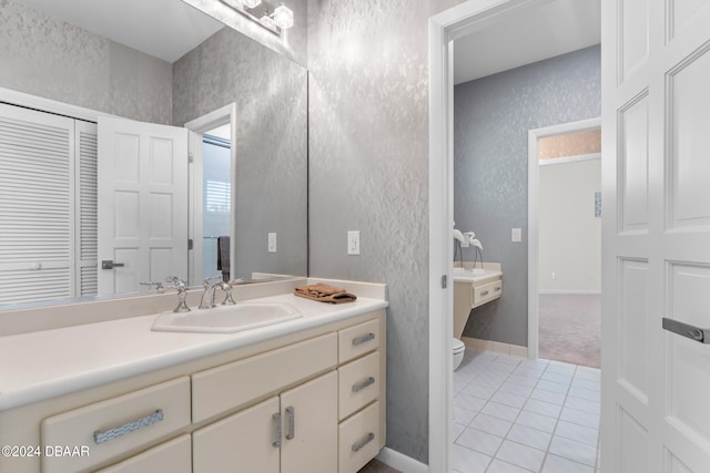 bathroom featuring toilet, vanity, and tile patterned flooring