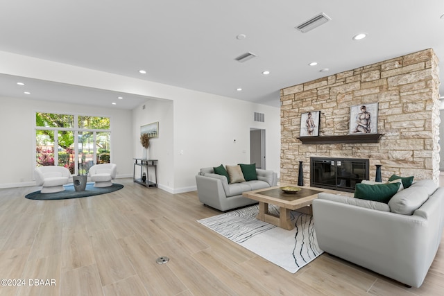 living room with a fireplace and light wood-type flooring