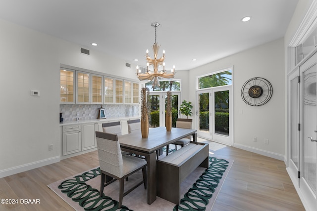 dining space featuring light wood-type flooring and an inviting chandelier