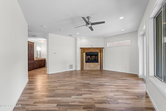 unfurnished living room featuring ceiling fan and light hardwood / wood-style floors