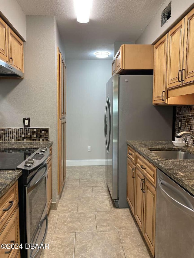 1401 S Palmetto Ave Unit 214, Daytona Beach, FL 32114 - kitchen with stainless steel appliances, a sink, a textured ceiling, brown cabinets, and dark stone countertops