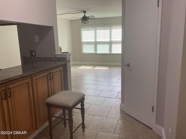 kitchen with dark stone counters and ceiling fan