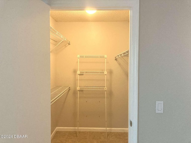 walk in closet with tile patterned floors