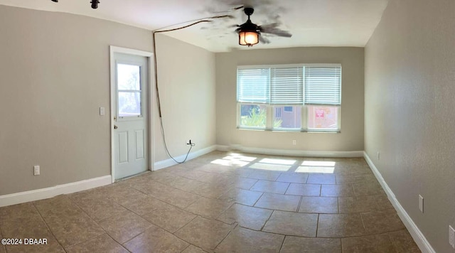 empty room featuring ceiling fan, a healthy amount of sunlight, and light tile patterned floors