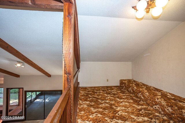 bonus room featuring a notable chandelier and vaulted ceiling with beams