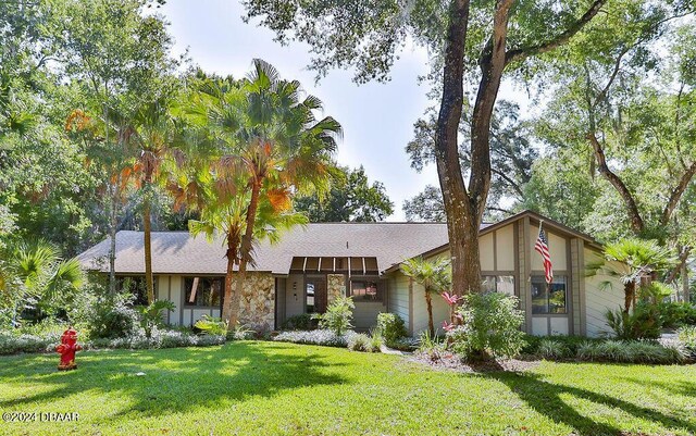 121 Willow Bend Ln, Ormond Beach, FL 32174 - mid-century inspired home with a front yard and stone siding