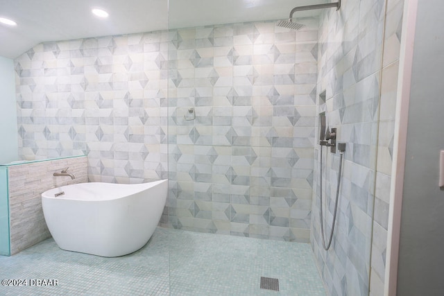 bathroom with tile walls, shower with separate bathtub, and tile patterned floors