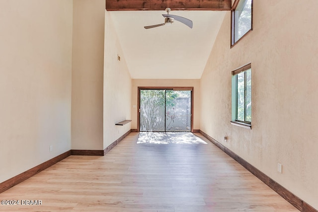 empty room with light hardwood / wood-style floors, ceiling fan, and high vaulted ceiling