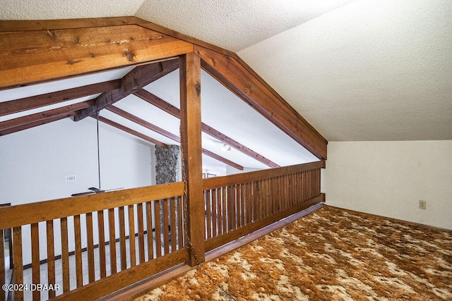 bonus room with a textured ceiling and vaulted ceiling with beams