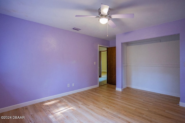 unfurnished bedroom with ceiling fan, a closet, and light wood-type flooring