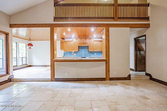 kitchen with sink, tasteful backsplash, wooden ceiling, high vaulted ceiling, and light brown cabinetry