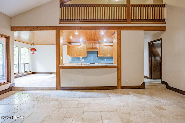 121 Willow Bend Ln, Ormond Beach, FL 32174 - kitchen with stone tile floors, high vaulted ceiling, baseboards, a sink, and light countertops