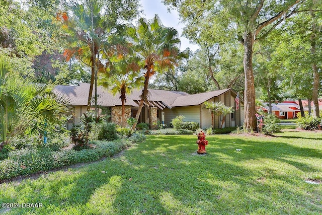 121 Willow Bend Ln, Ormond Beach, FL 32174 - mid-century home featuring a front yard and stone siding