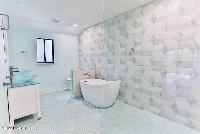 121 Willow Bend Ln, Ormond Beach, FL 32174 - bathroom featuring double vanity, a freestanding bath, recessed lighting, toilet, and tile walls