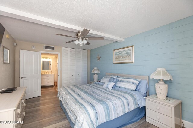 bedroom with visible vents, ceiling fan, wood finished floors, a closet, and a textured ceiling